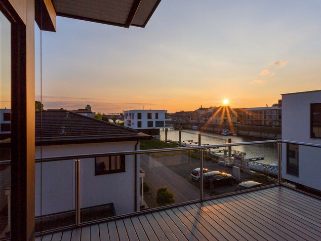 Balkonblick auf Bestandshaus mit Sonnenuntergang und Wasserblick