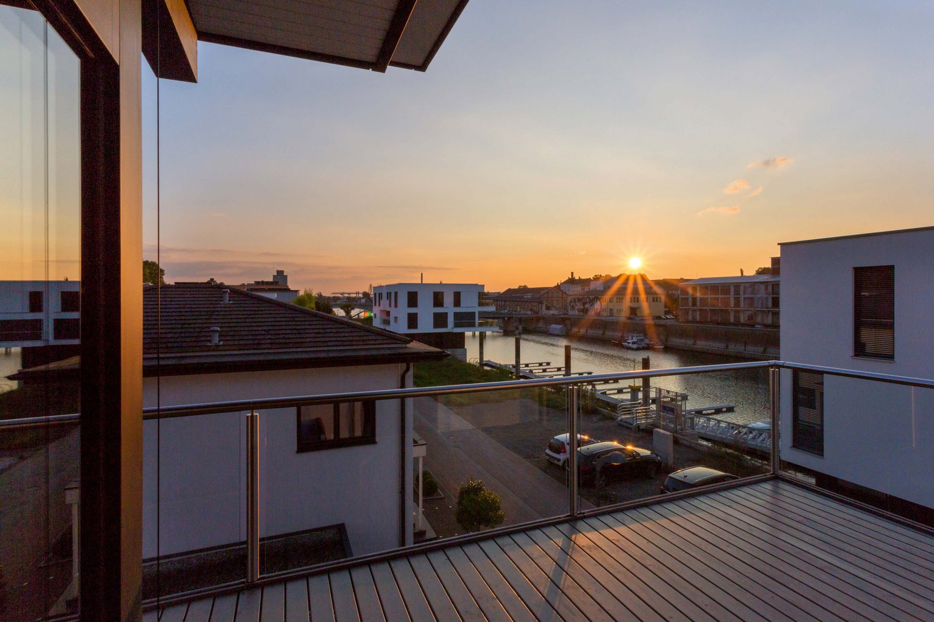 Bestandshaus mit HUF Aufstockung Balkonblick auf Bestandshaus mit Sonnenuntergang und Wasserblick