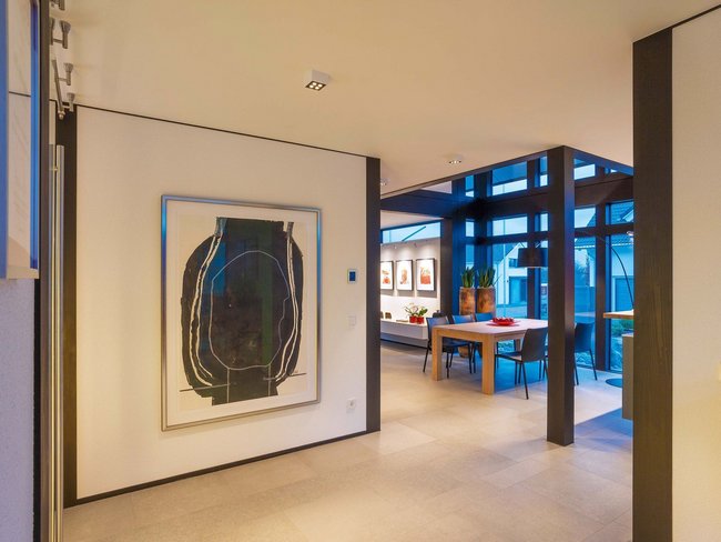 HUF Haus modum 810 Musterhaus Wuppertal 9 Heller Flur mit moderner Kunst und Essbereich in einem modernen Zuhause
