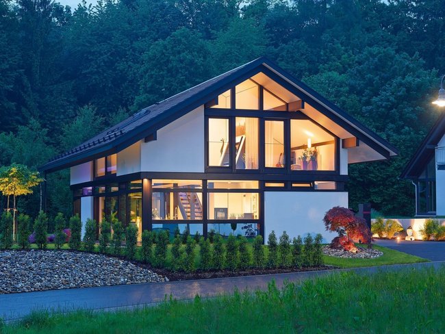 Gemütliches Architektenhaus umgeben von grüner Landschaft bei Nacht