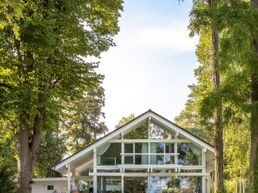 Architektenhaus mit großen Fenstern und grünem Garten