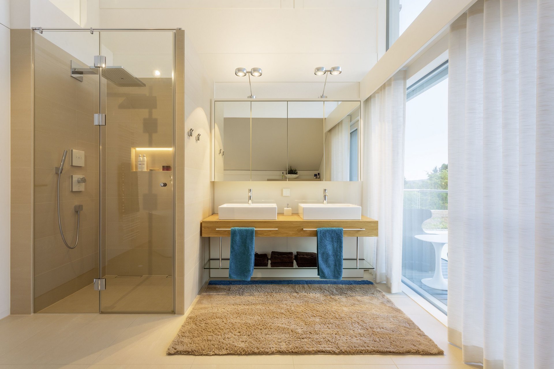 Helles Badezimmer mit moderner Einrichtung und Dusche Schickes Badezimmer mit Doppelwaschbecken und Glasdusche