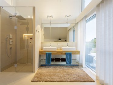 Schickes Badezimmer mit Doppelwaschbecken und Glasdusche