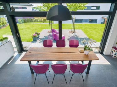 Moderne Esszimmeransicht mit Holzstuhl und Gartenblick