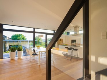 Helle und stilvolle Wohnküche mit Holzboden und großen Fenstern