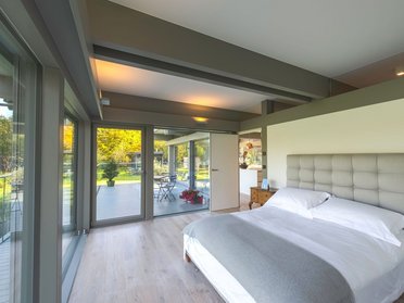 Stilvoller HUF Anbau mit harmonischem Wohnraum Schlafzimmer im modernen HUF Anbau mit Blick auf den Garten