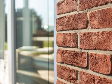 Detailaufnahme einer Backsteinmauer neben einem Fenster