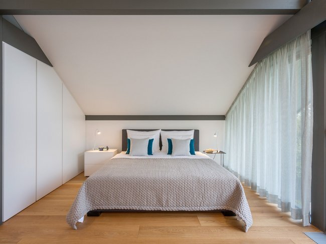 Modernes Schlafzimmer mit großen Fenstern und Doppelbett Helles Schlafzimmer mit minimalistischer Einrichtung und Holzboden