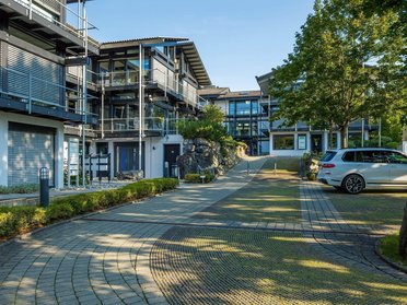 Ansicht des Bürogebäudes HUF mit Parkplatz und Landschaftsgestaltung