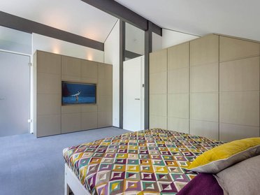 HUF house modum 810 22 Helles Schlafzimmer mit TV und geometrischem Bettüberwurf