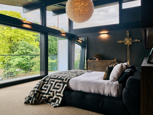 Luxuriöses Schlafzimmer mit Blick auf die Natur und stilvollen Akzenten