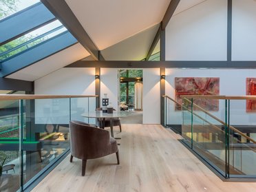 Innenansicht eines modernen Hauses mit großem Fenster und gemütlicher Einrichtung