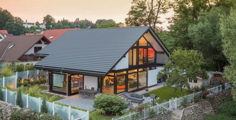 Helles Haus mit großen Fenstern und Gartenlandschaft