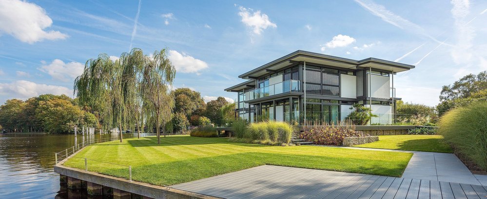 Elegantes modernes Haus mit Glasverkleidung und Grünflächen