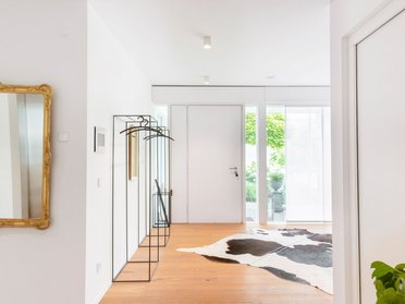 Heller Eingangsbereich eines modernen Hauses mit Holzfußboden und Dekoration