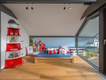Gemütliches Zimmer mit maritimem Design und Aussicht Modernes Zimmer mit blauem Bett und maritimen Dekoren.