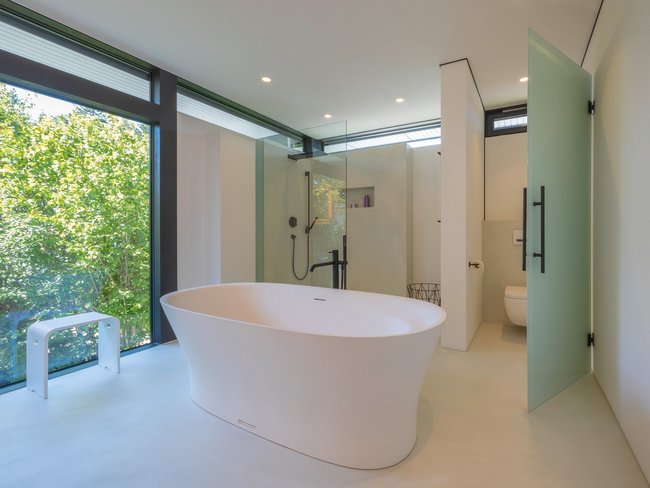 Lichtdurchflutetes Architektenhaus mit modernem Bad Helles Badezimmer mit freistehender Badewanne und Glasduschbereich
