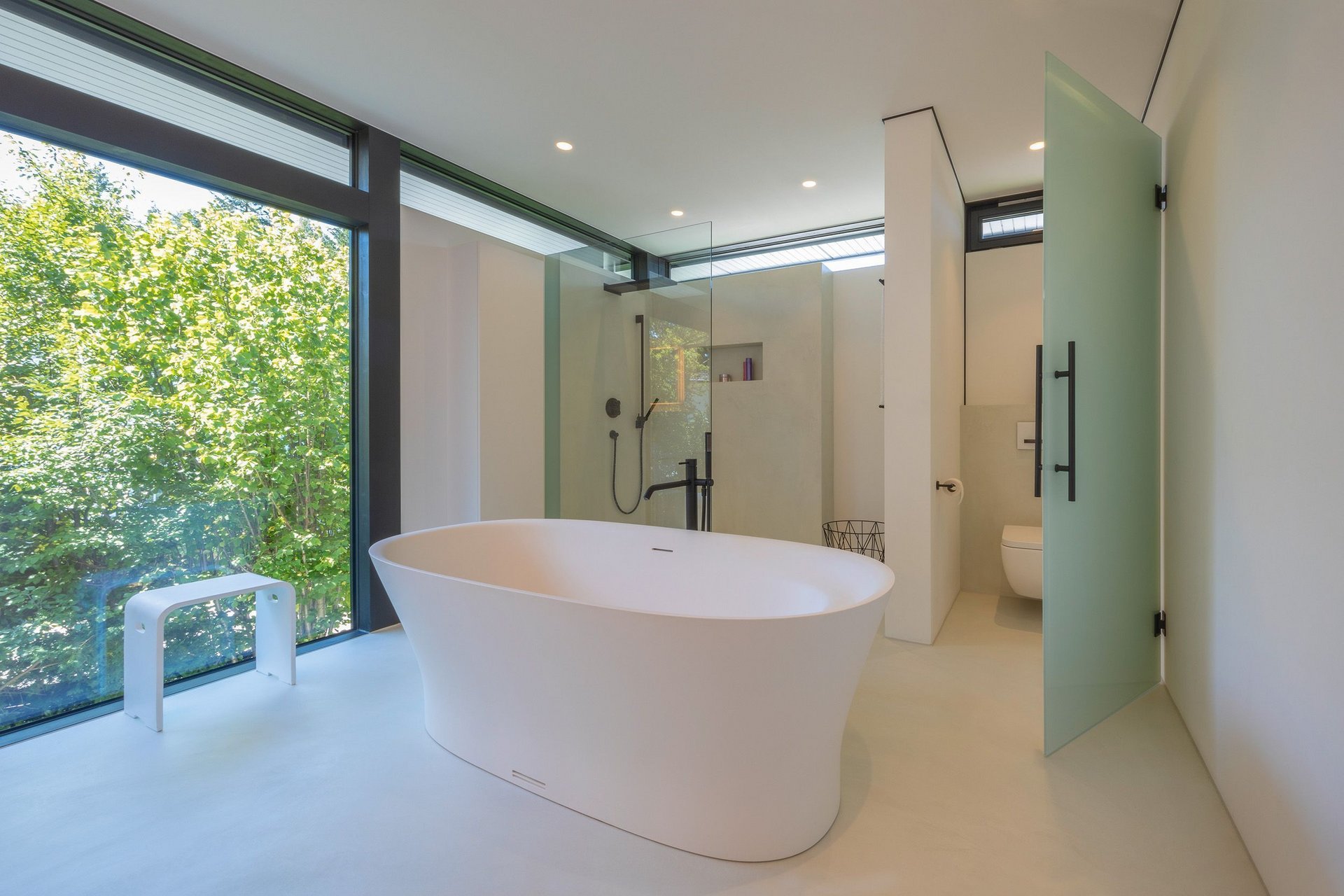 Lichtdurchflutetes Architektenhaus mit modernem Bad Helles Badezimmer mit freistehender Badewanne und Glasduschbereich