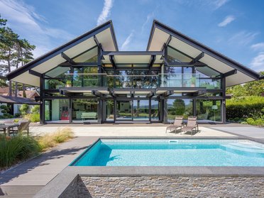 Modernes Haus mit Pool und großen Fenstern in freier Natur