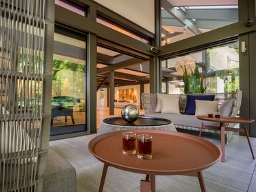 Ein stilvoller Wohnbereich mit Cocktails auf einem Tisch und Kunstwerken im Hintergrund