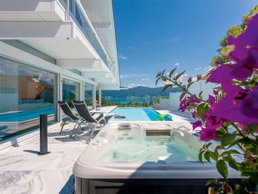 Terrassengarten mit Pool und Blick auf sanfte Hügel und See