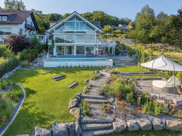 Hochwertiges Designhaus umgeben von gepflegtem Garten und Terrasse