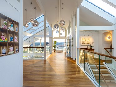 Großzügiger Raum mit Holzfußboden und modernen Leuchten