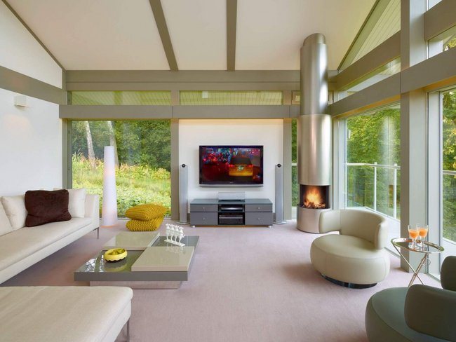 Modernes Design im HUF Bungalow mit Glasflächen Helles Wohnzimmer im HUF Bungalow mit großer Fensterfront und moderner Einrichtung
