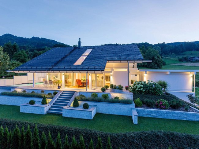 Moderne Architektur mit Blick auf Hügel und See bei Dämmerung