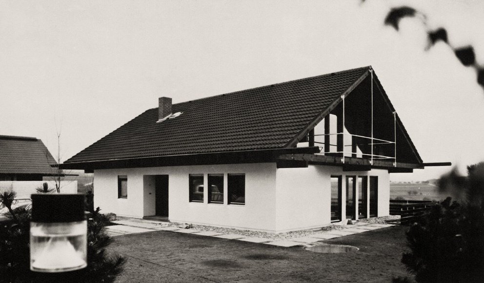 Modernes Einfamilienhaus mit Walmdach Schwarz-weiß Bild eines modernen Hauses mit großen Fenstern und Parkplatz