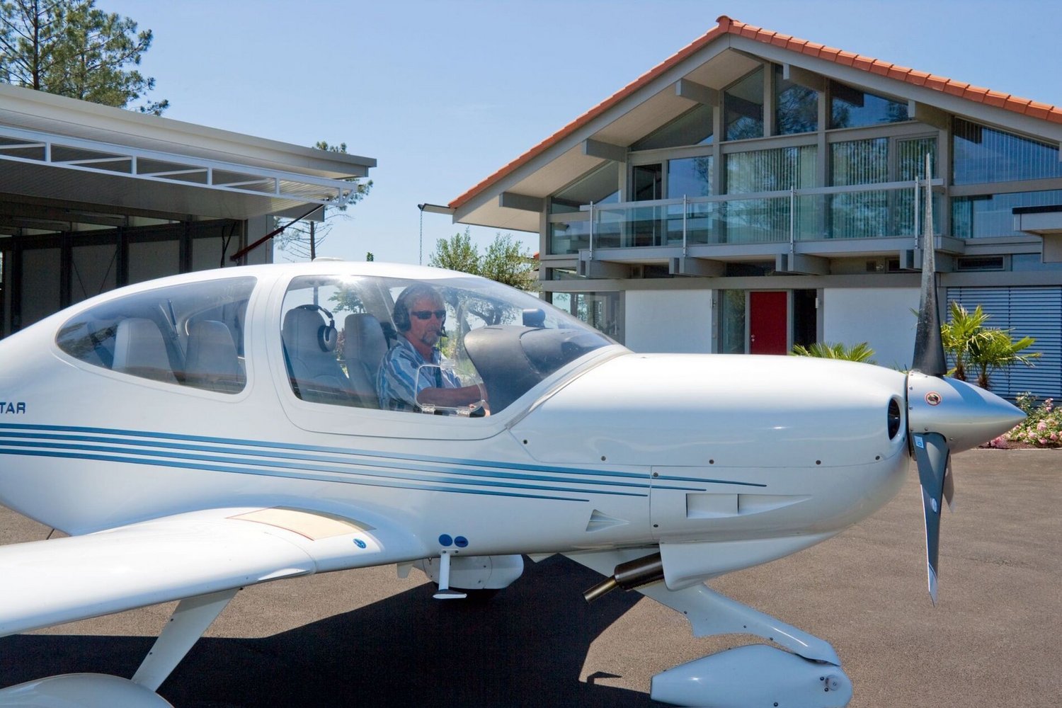 Flugzeug vor einem stilvollen HUF Haus mit Hangar