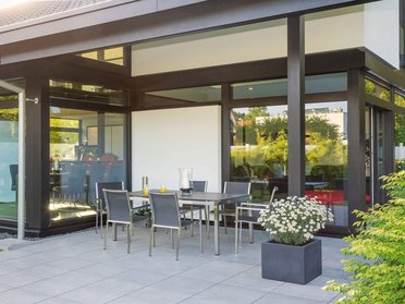 Ansicht eines Architektenhauses mit Essbereich im Freien und Pflanzen