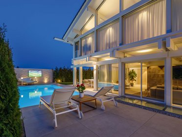 HUF Haus mit moderner Architektur und beleuchtetem Pool