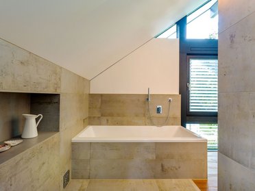Modernes Badezimmer mit Badewanne und Holzfenster für viel Licht