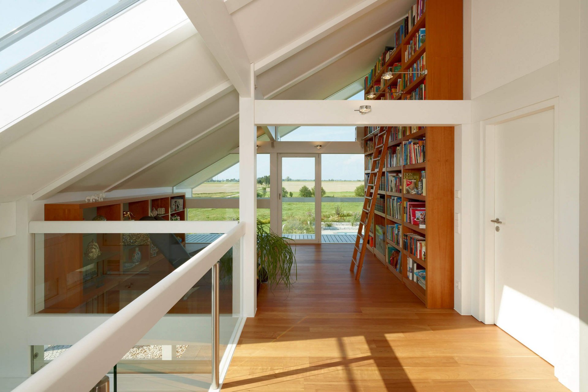 Moderne Architektur eines lichtdurchfluteten Raums Innenansicht eines modernen Raums mit Bücherregalen und großen Fenstern