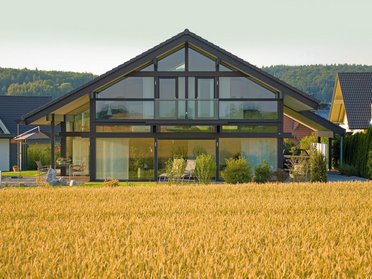 Stilvolles Haus mit großen Fenstern und Garten im Vordergrund