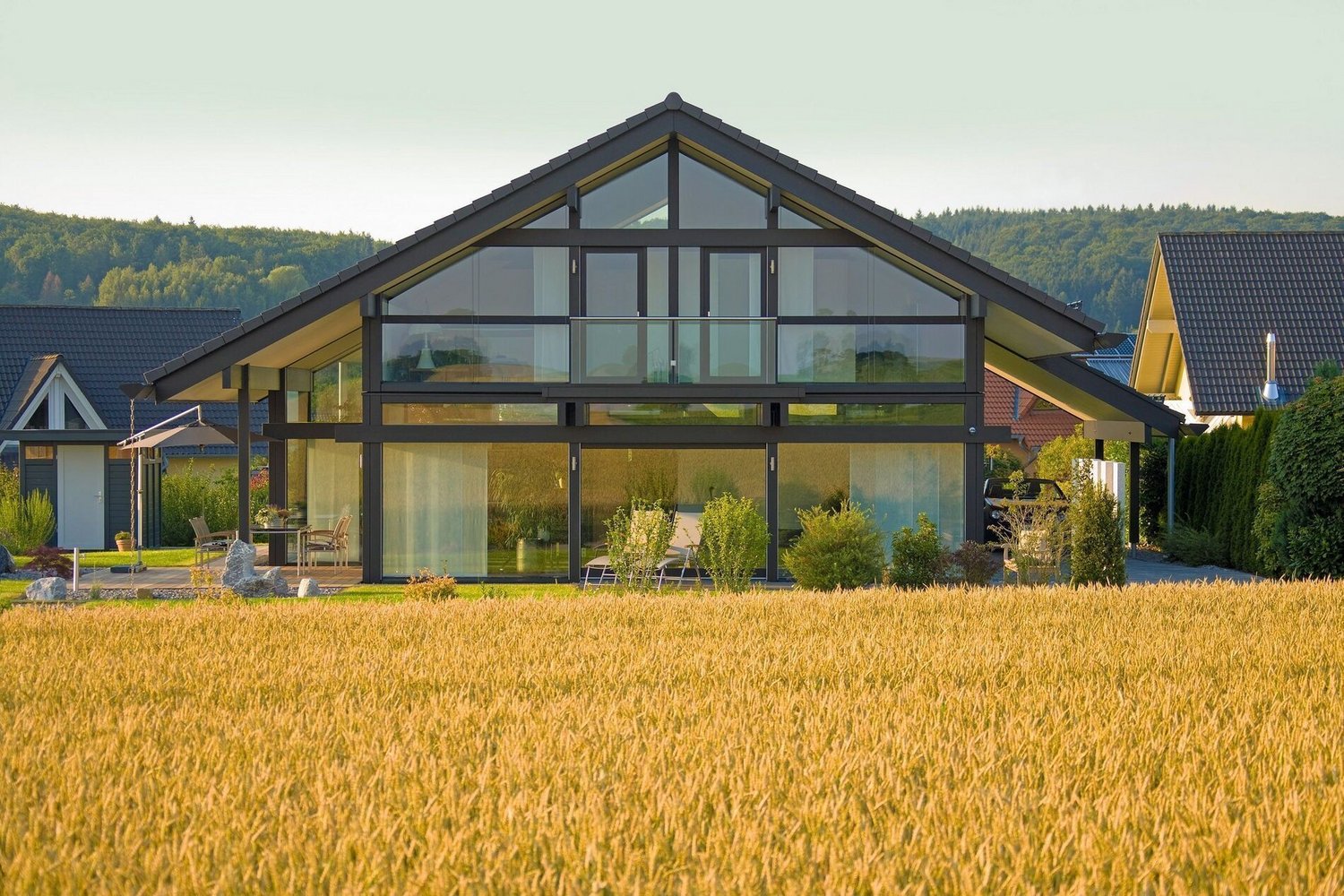 Stilvolles Haus mit großen Fenstern und Garten im Vordergrund