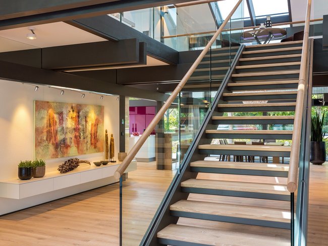 Elegante Treppe mit Glasgeländer in einem stilvollen Innenraum