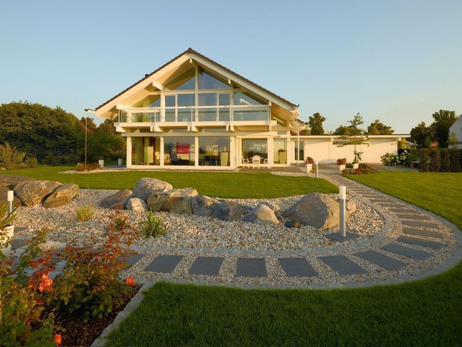 Fachwerkhaus HUF HAUS ART 4 mit schöner Gartenlandschaft Moderne Architektur eines Fachwerkhauses mit gepflegtem Außenbereich.