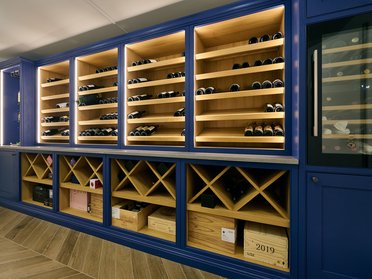 Weinregal mit Holzregalen und eleganter Beleuchtung
