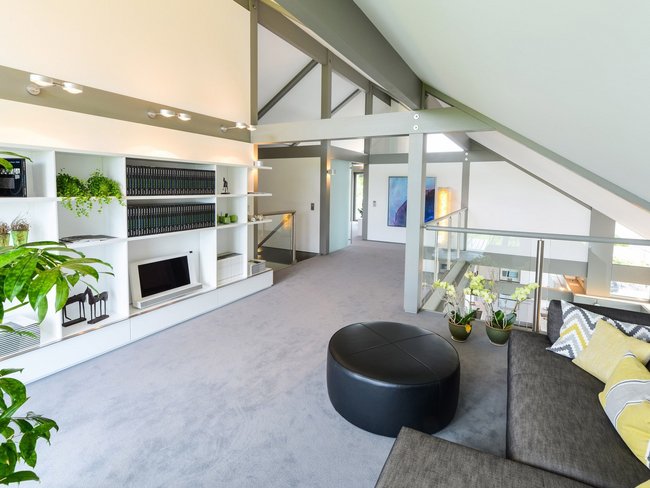 Heller Wohnbereich mit Sofa, Pflanzen und Regalen im Loft-Stil