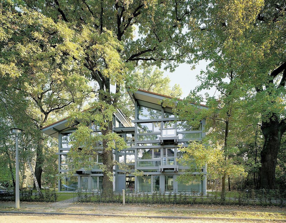 Modernes Bürogebäude von HUF umgeben von Bäumen und Natur.