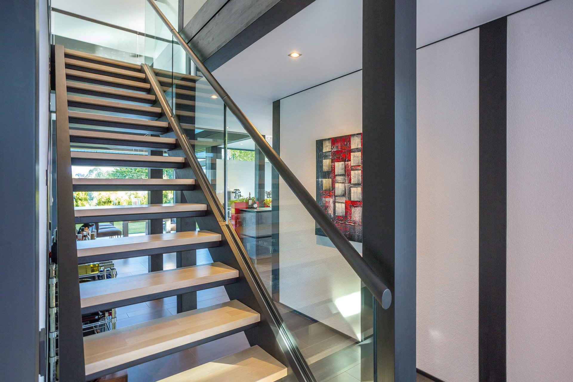 Innenansicht einer modernen Treppe mit Glasgeländer und Holzstufen
