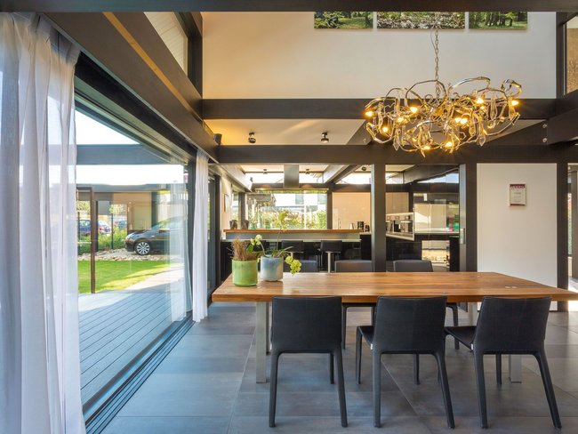 Dynamisches Design mit Holztisch, Stühlen und moderner Beleuchtung.