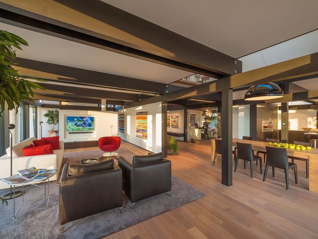 Heller Wohnraum mit Sofa, Stühlen und modernen Kunstwerken
