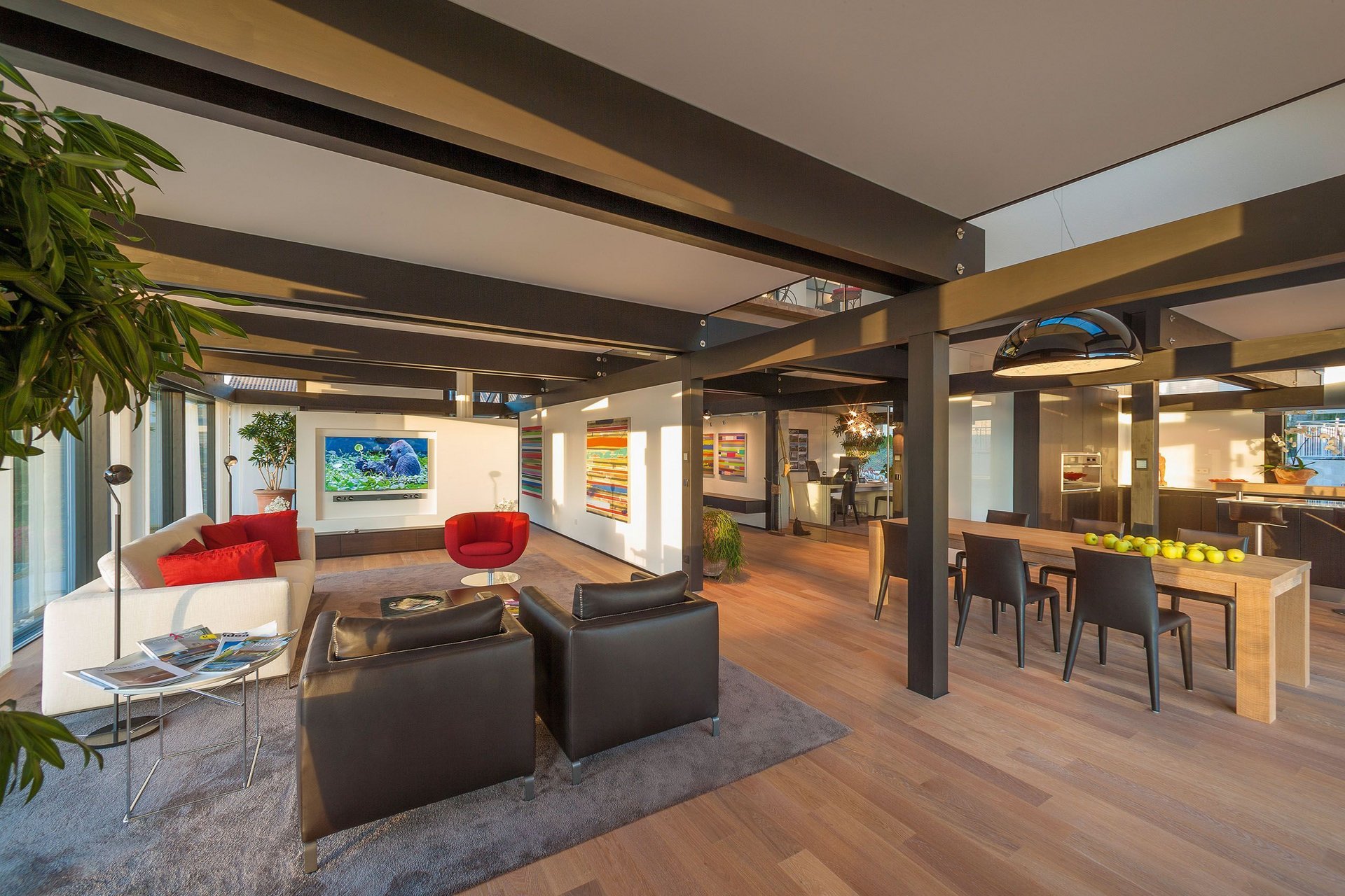 Heller Wohnraum mit Sofa, Stühlen und modernen Kunstwerken