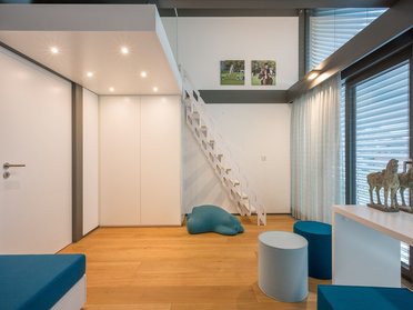 Modernes Wohninterieur mit Treppe und Dekoration Helles Zimmer mit Treppe, Möbeln und Kunstwerken an der Wand