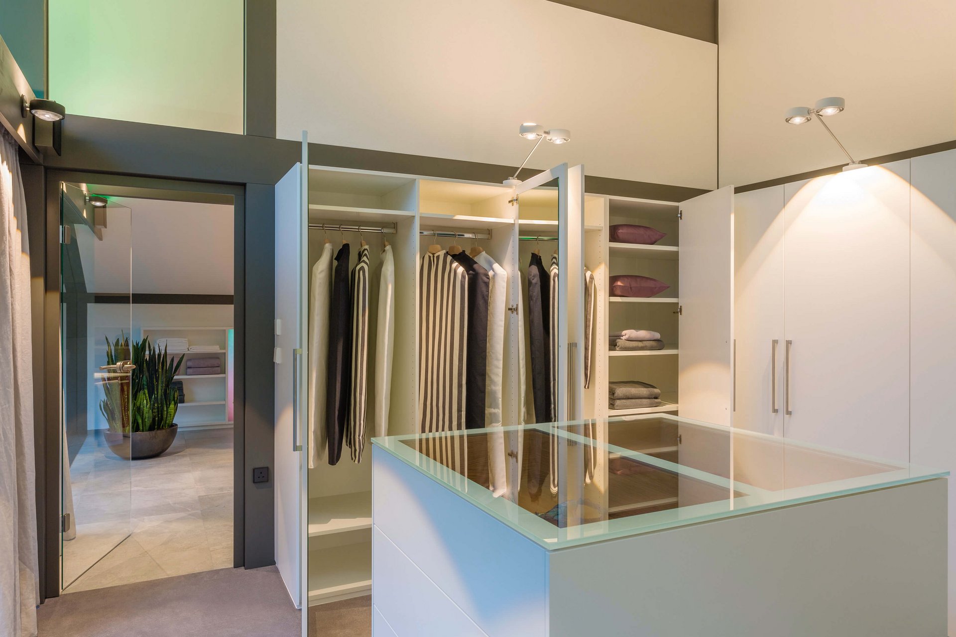 Begehbarer Kleiderschrank mit Glastisch und stilvollen Regalen