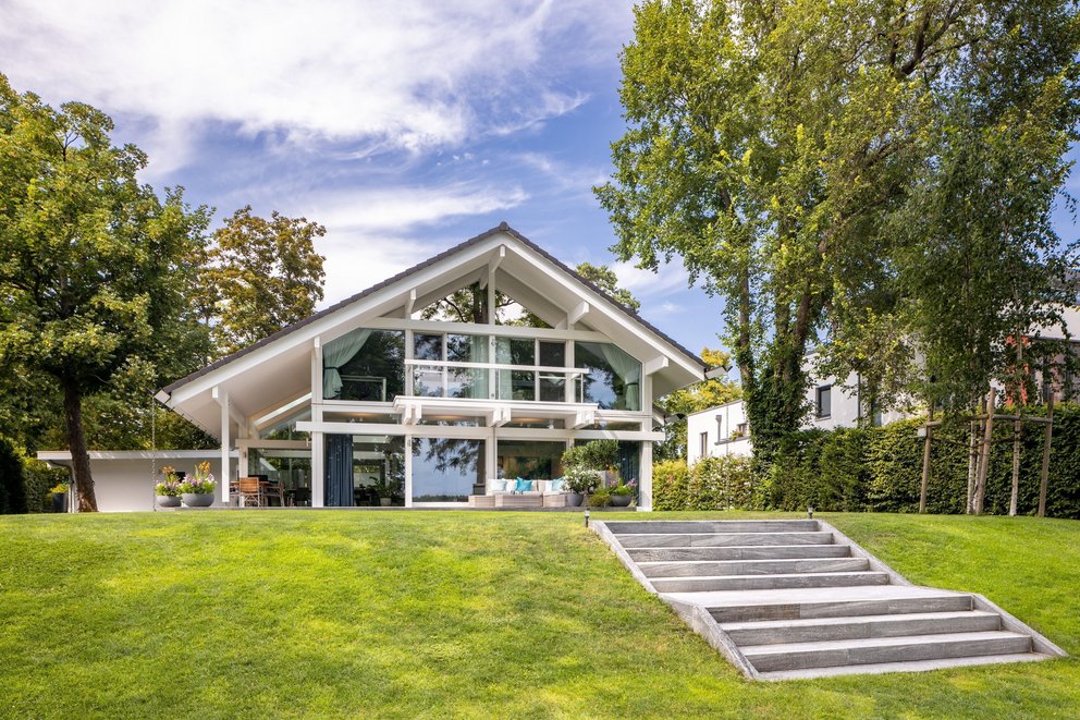 Architektenhaus am Wasser mit großflächigen Fenstern und gepflegtem Garten