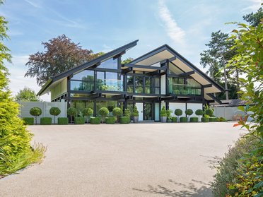 Modernes Haus mit großen Fenstern und schönem Garten